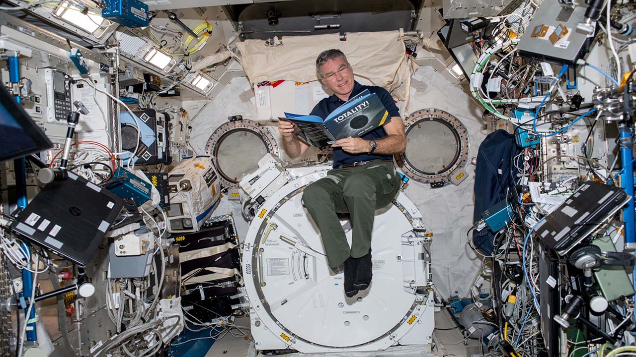 NASA astronaut Steve Bowen reads Totality! An Eclipse Guide in Rhyme and Science onboard the International Space Station